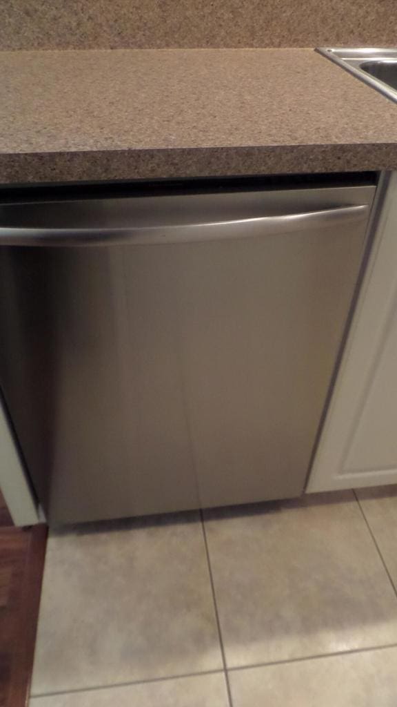 room details with white cabinetry and stainless steel dishwasher