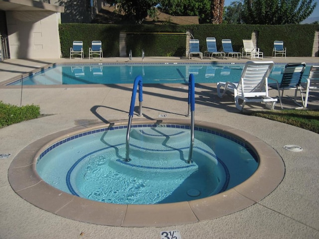 view of swimming pool with a patio and a hot tub