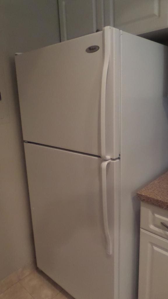 room details with white fridge and white cabinetry