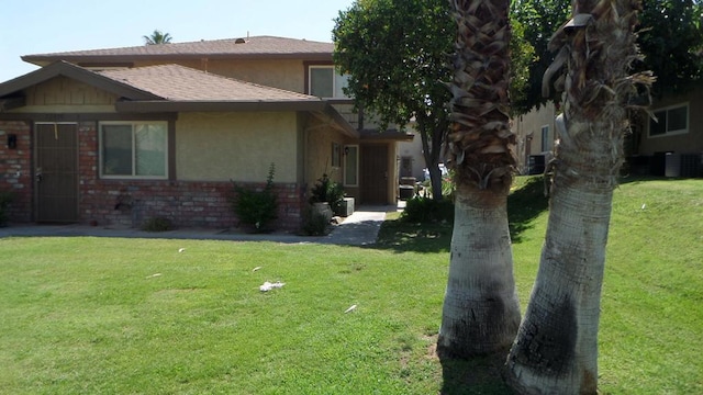 view of side of property with central AC and a yard