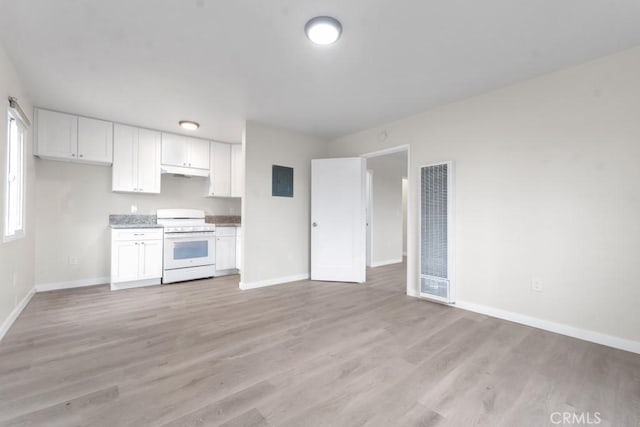 kitchen featuring electric panel, white cabinets, white stove, and light wood-type flooring