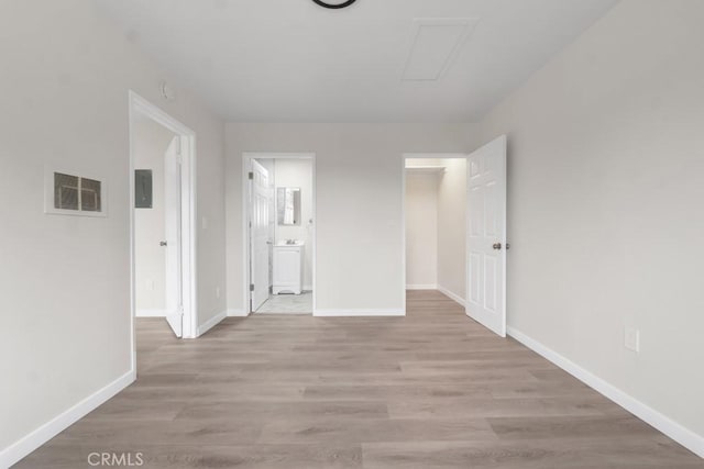 interior space featuring electric panel and light hardwood / wood-style floors