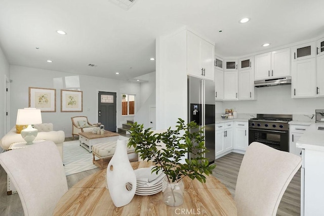 kitchen with white cabinets, light wood-type flooring, and premium appliances