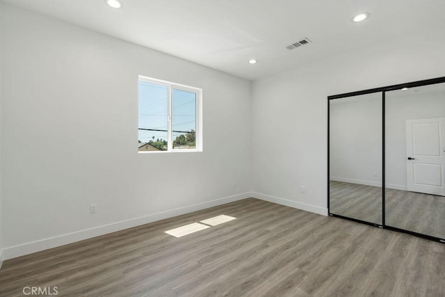 unfurnished bedroom with a closet and light hardwood / wood-style floors