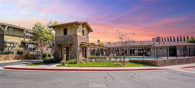 outdoor building at dusk featuring a community pool