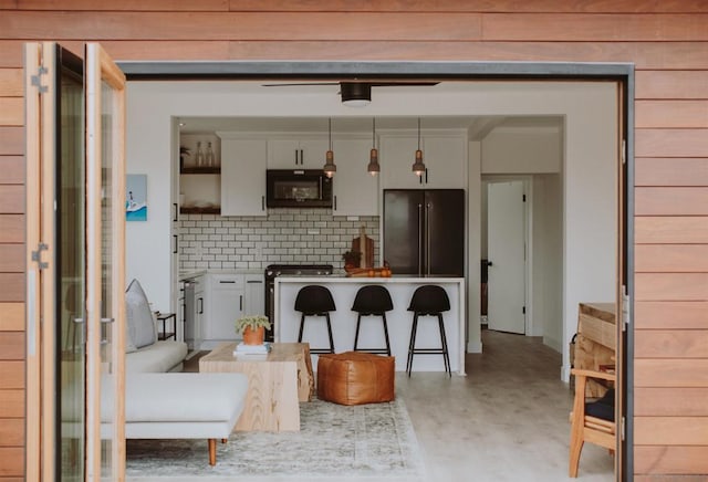 kitchen featuring wood-type flooring, backsplash, white cabinets, and high end refrigerator