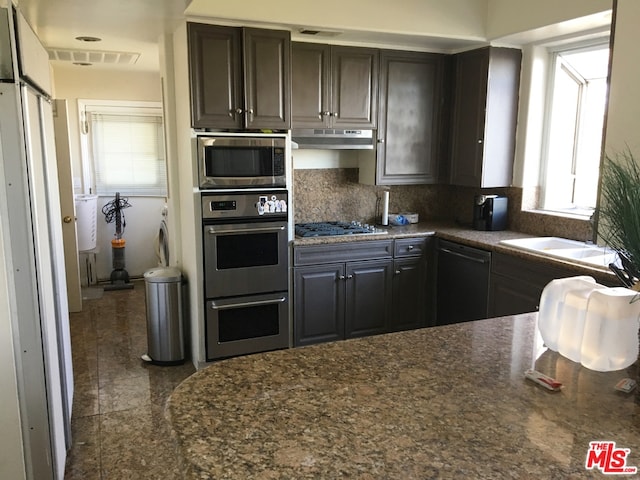 kitchen featuring black dishwasher, tasteful backsplash, sink, stainless steel gas cooktop, and dark brown cabinets