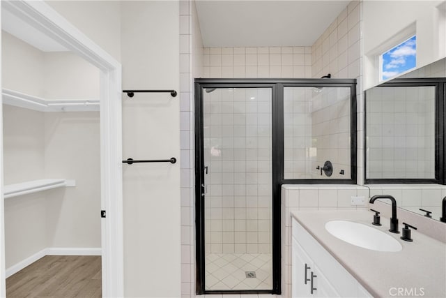 bathroom featuring hardwood / wood-style floors, vanity, and a shower with shower door