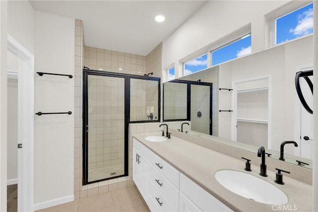 bathroom with tile patterned flooring, vanity, and a shower with door