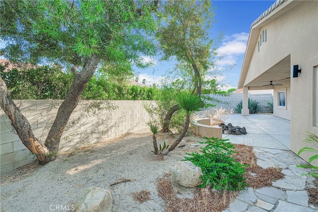 view of yard featuring ceiling fan and a patio