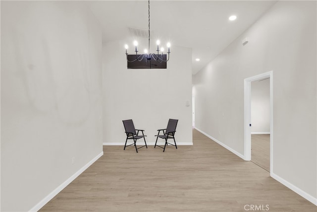 living area with a chandelier and light hardwood / wood-style floors