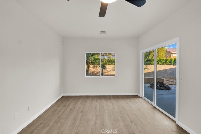 empty room featuring light hardwood / wood-style floors, a wealth of natural light, and ceiling fan