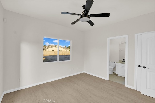 unfurnished bedroom featuring ceiling fan, light wood-type flooring, connected bathroom, and a closet