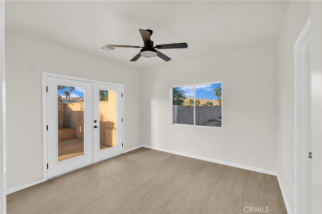 unfurnished room featuring french doors, light wood-type flooring, and ceiling fan