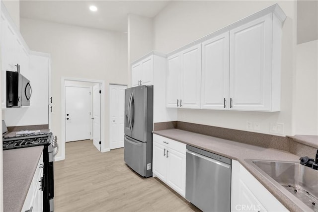 kitchen featuring light hardwood / wood-style flooring, stainless steel appliances, white cabinetry, and sink