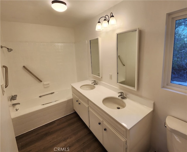 full bathroom with vanity, toilet, hardwood / wood-style flooring, and tiled shower / bath