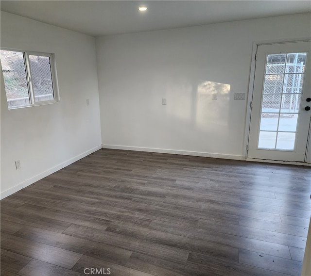 spare room with dark hardwood / wood-style floors and plenty of natural light