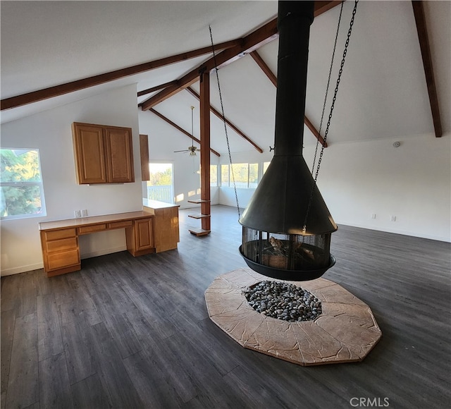 interior space with beam ceiling, hardwood / wood-style flooring, a wood stove, and ceiling fan