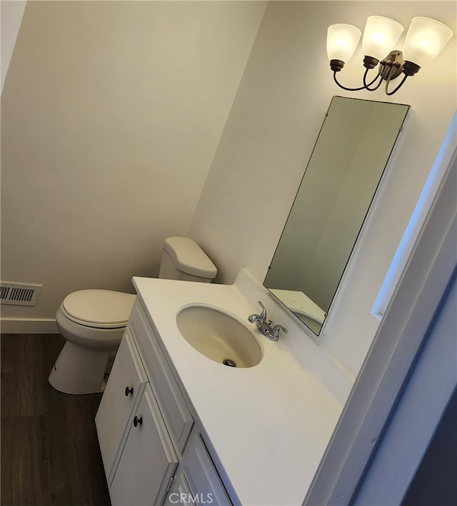 bathroom featuring toilet, hardwood / wood-style floors, and vanity