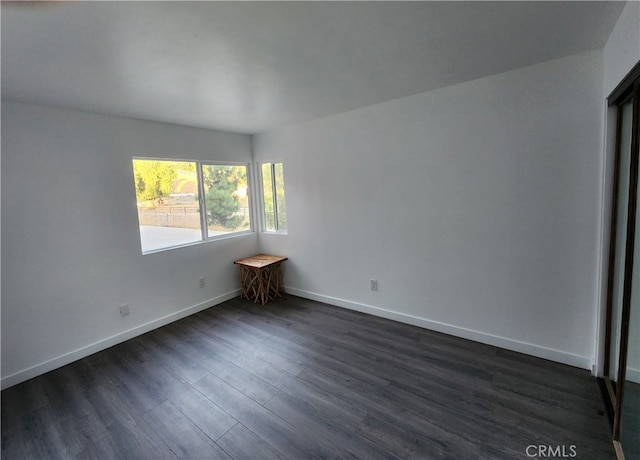 unfurnished room with dark wood-type flooring