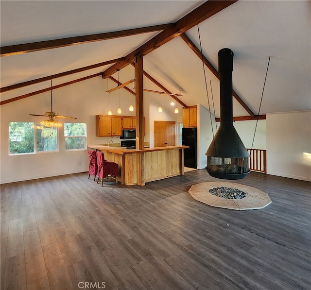 unfurnished living room featuring a wood stove, ceiling fan, beamed ceiling, high vaulted ceiling, and dark hardwood / wood-style floors