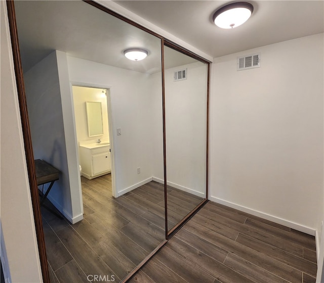 unfurnished bedroom featuring dark wood-type flooring and a closet