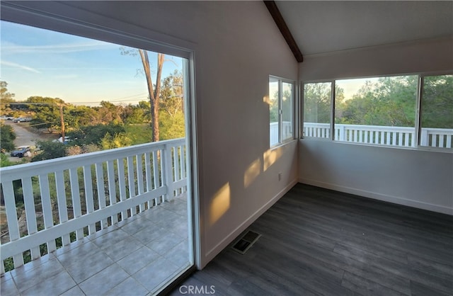 unfurnished sunroom with lofted ceiling with beams and plenty of natural light