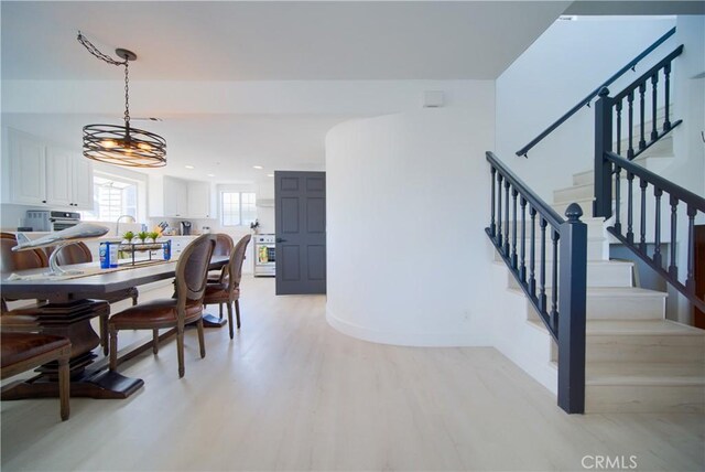 dining area featuring light hardwood / wood-style floors, an inviting chandelier, and sink