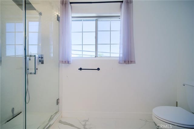 bathroom featuring toilet and a shower with door