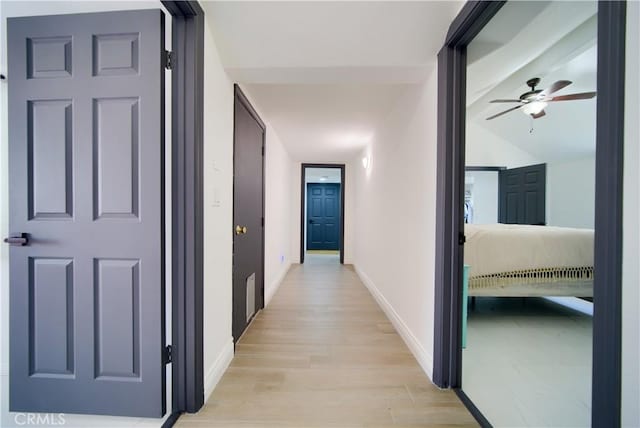 hall featuring light hardwood / wood-style floors and vaulted ceiling