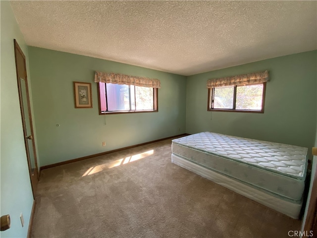 unfurnished bedroom with carpet floors and a textured ceiling