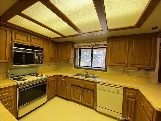 kitchen featuring white appliances, a textured ceiling, and sink