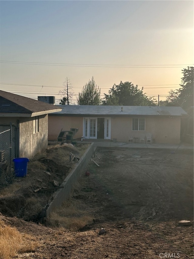 back house at dusk featuring a patio area and french doors