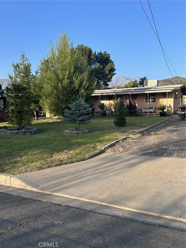 view of front of property featuring a mountain view and a front yard