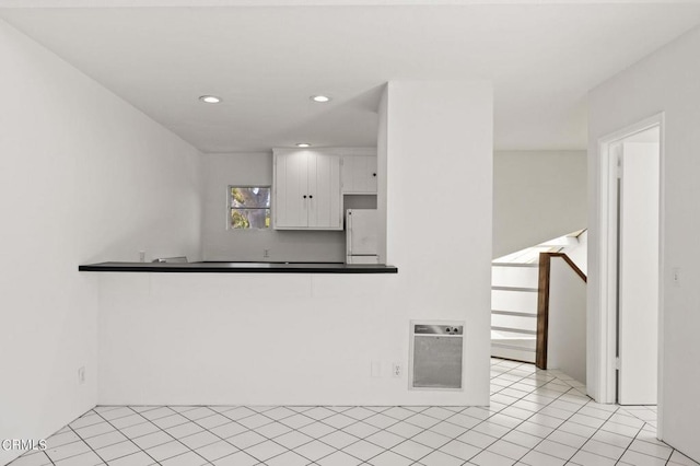 unfurnished living room featuring light tile patterned floors and heating unit