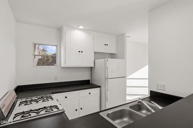 kitchen featuring sink, white cabinets, and white appliances