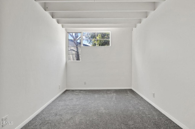 spare room featuring beamed ceiling and carpet floors