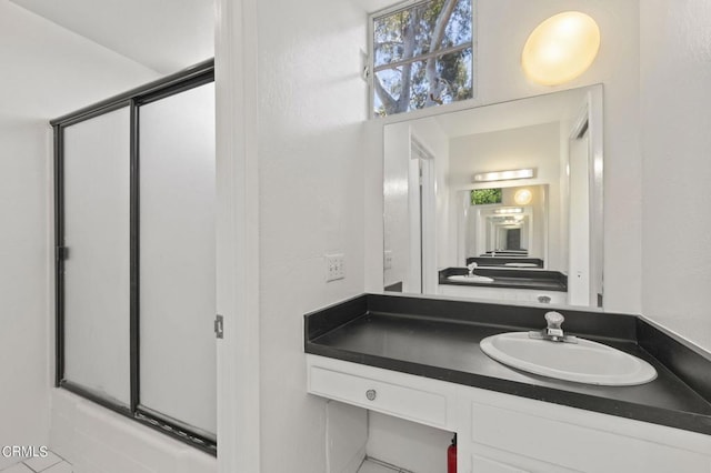 bathroom with vanity and combined bath / shower with glass door