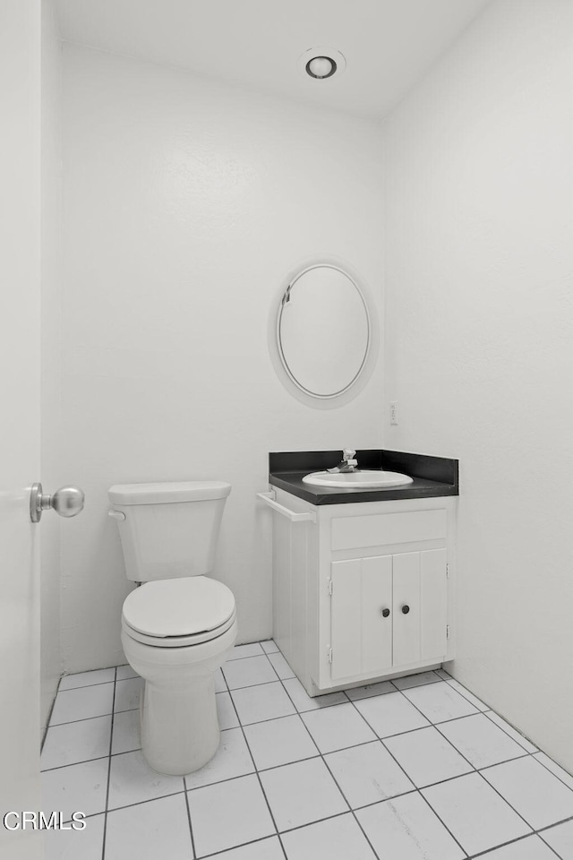 bathroom featuring tile patterned flooring, vanity, and toilet