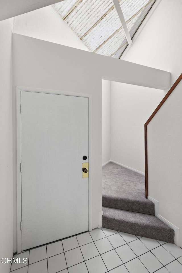 carpeted foyer with lofted ceiling