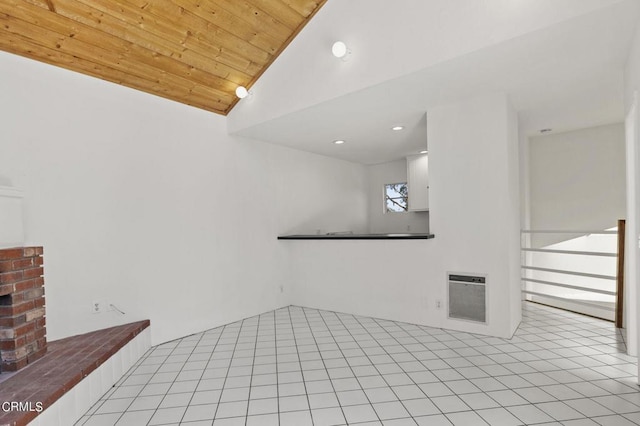 interior space with light tile patterned floors, heating unit, vaulted ceiling, and wooden ceiling