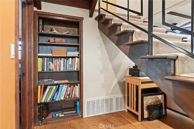 stairway featuring hardwood / wood-style floors and built in features