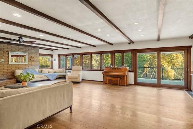 living room with beam ceiling, hardwood / wood-style flooring, plenty of natural light, and ceiling fan