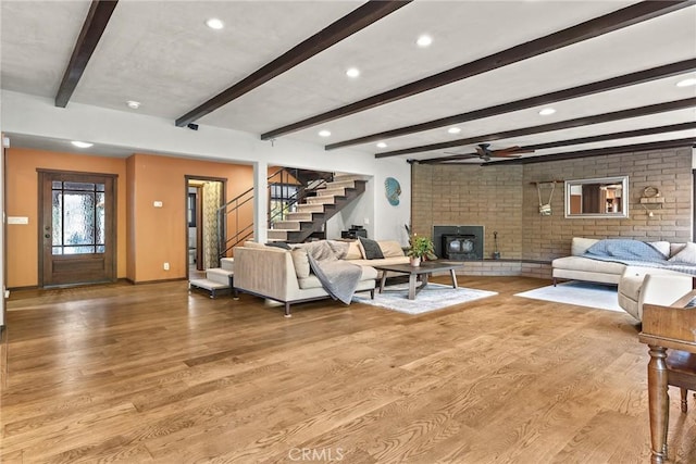 living room featuring beam ceiling, ceiling fan, and light hardwood / wood-style floors