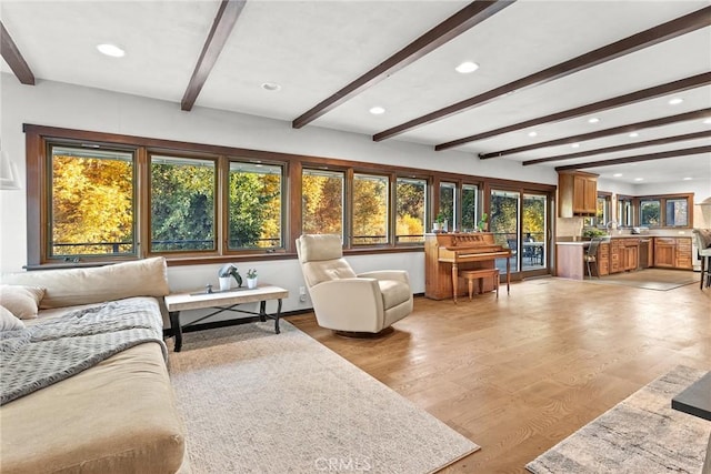 living room with beamed ceiling and light hardwood / wood-style floors