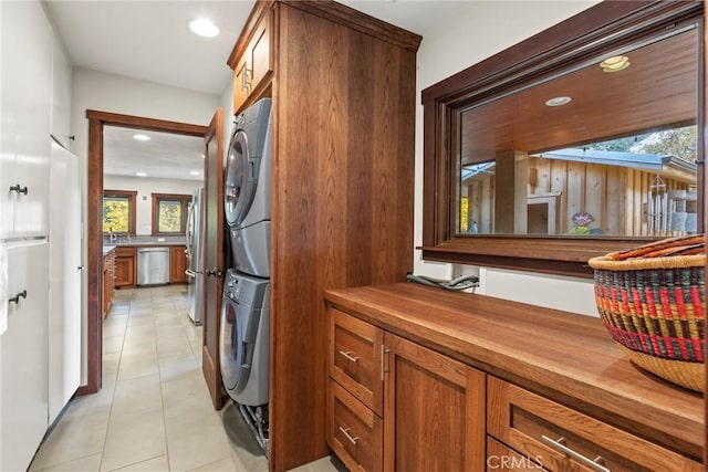 laundry area featuring stacked washer and dryer and light tile patterned floors