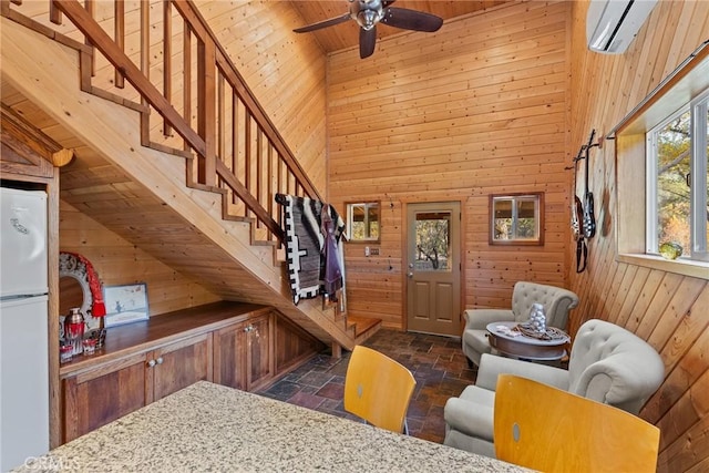 interior space with a wall mounted air conditioner, high vaulted ceiling, wood ceiling, and wood walls