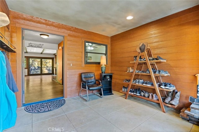 miscellaneous room featuring tile patterned flooring and wooden walls