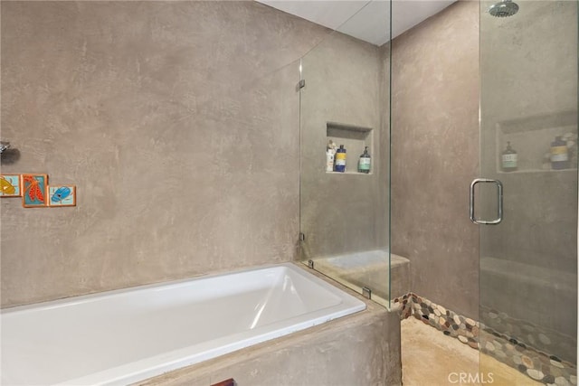 bathroom featuring shower with separate bathtub