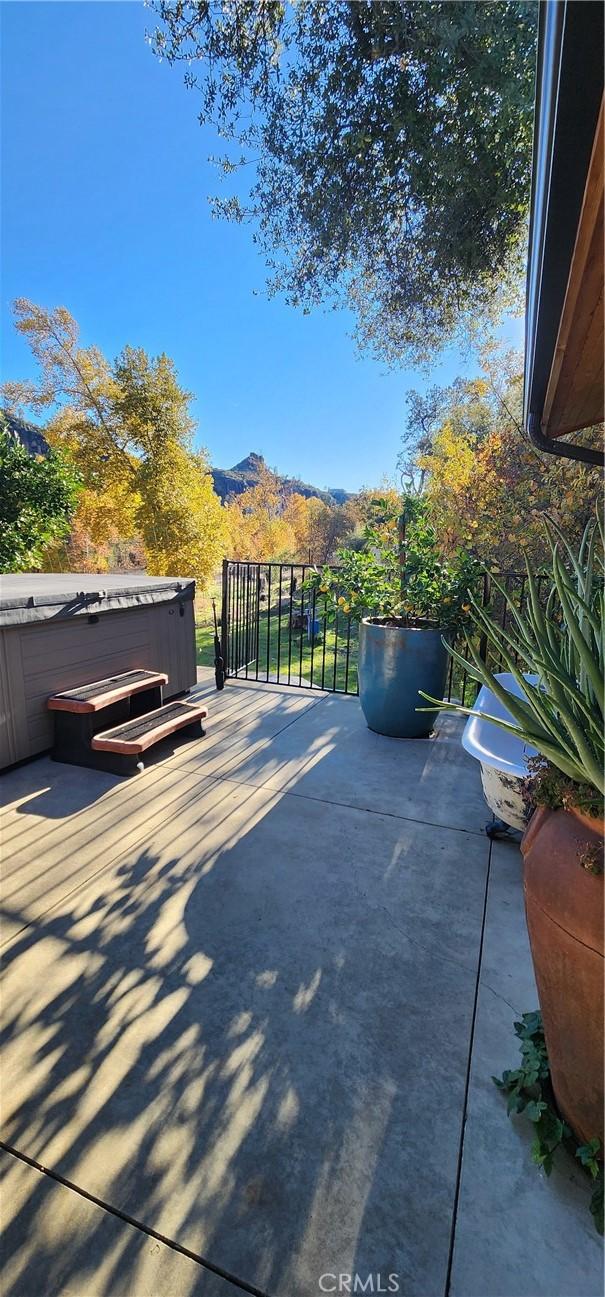 view of patio featuring a mountain view and a hot tub